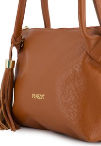 Braune Lederhandtasche mit strukturiertem Oberflächen, goldenen Beschlägen und Quastendetail. Mit dem "VENEZIA"-Logo an der Seite.