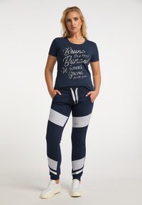Marine sportoutfit bestaande uit een T-shirt met ronde hals met metallic tekst en bijpassende sweatpants met grijze zijpanelen en een trekkoord in de taille.