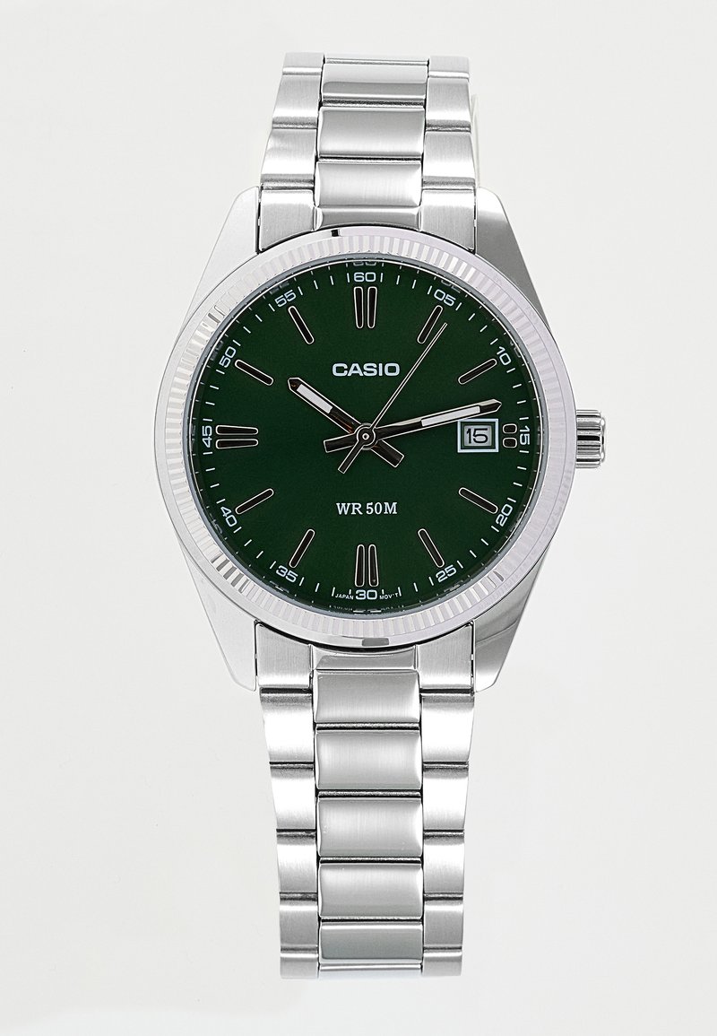 Montre-bracelet Casio argentée avec cadran vert, index horaires argentés, trois aiguilles, affichage de la date et bracelet à maillons en métal.