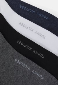 Sosete din bumbac în negru, alb, bleumarin și gri; fiecare are logo-ul "Tommy Hilfiger" în culori contrastante aproape de vârf.