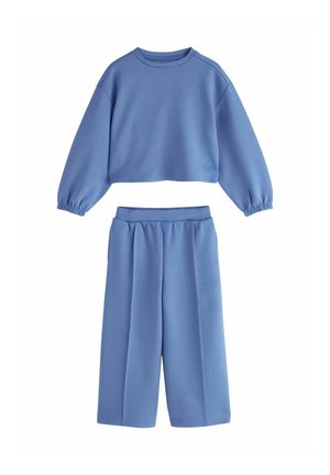 Blå cropped sweatshirt med lange ærmer og elastiske manchetter samt matchende vidde bukser med elastisk talje.