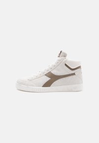 High-top sneaker in light beige suede with dark brown accents, featuring a textured rubber sole and lace-up front.