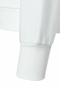 Weißer Sweatshirtbund mit geripptem Muster und weichem Material. Nahtdetails sichtbar, wo der Bund auf den Ärmel trifft, was einen sanften Übergang schafft.