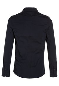 Back view of a fitted, long-sleeve, dark navy shirt with buttoned cuffs and a classic collar.