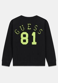 Felpa nera con una grafica audace e pelosa in neon verde "GUESS 81" sul retro, con un classico scollo a girocollo e maniche lunghe.