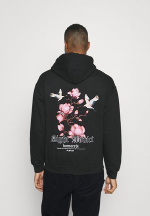 Felpa nera con cappuccio caratterizzata da un design floreale con fiori rosa e uccelli bianchi sul retro, con il testo "Night Addict" e "komorebi."