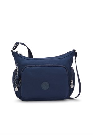 Navy blue shoulder bag made of durable fabric, featuring a main compartment, front zip pocket, and decorative keychain with a small figure.