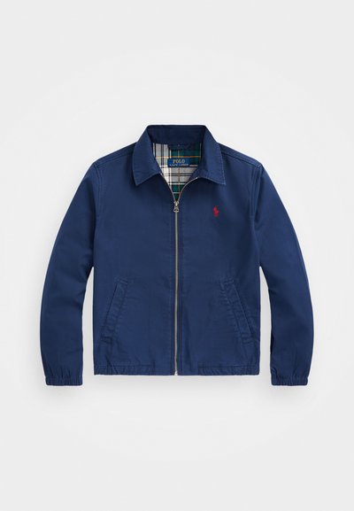 Marineblaue leichte Jacke mit Reißverschluss, verbreitertem Kragen, zwei Seitentaschen, elastischen Bündchen und kariertem Innenfutter. Kleines Logo auf der Brust.