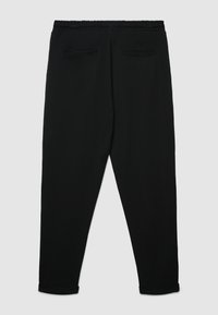 Pantaloni neri con elastico in vita, gambe affusolate e due tasche posteriori. Realizzati in tessuto liscio con una leggera lucentezza.