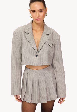 Grijze cropped blazer met krijtstrepen, voorzien van een reverskraag, enkele knoopsluiting en een bijpassende geplooide skort met een uitgesneden detail in de taille.