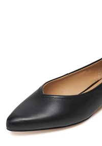 Czarne skórzane płaskie buty z ostrym czubkiem, z niskim wcięciem i gładką fakturą. Minimalistyczny design bez ozdób.