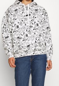 Felpa bianca con un motivo cartoon nero di palloni sportivi e personaggi, dotata di cappuccio con coulisse e polsini a costine.