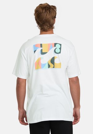 Camiseta de algodón blanca con un gráfico colorido en la parte posterior que presenta formas abstractas en naranja, azul y verde sobre un fondo más claro.