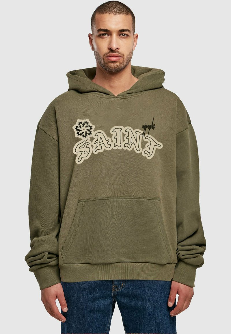 Sweat à capuche vert olive avec poche frontale, présentant "SAINT" dans une police ludique et un graphique floral. Tissu doux et texturé.