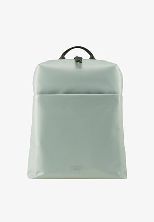 Mochila de nylon verde con textura suave, forma rectangular, asa superior y un bolsillo frontal con cremallera. Presenta un sutil logotipo en la parte inferior.