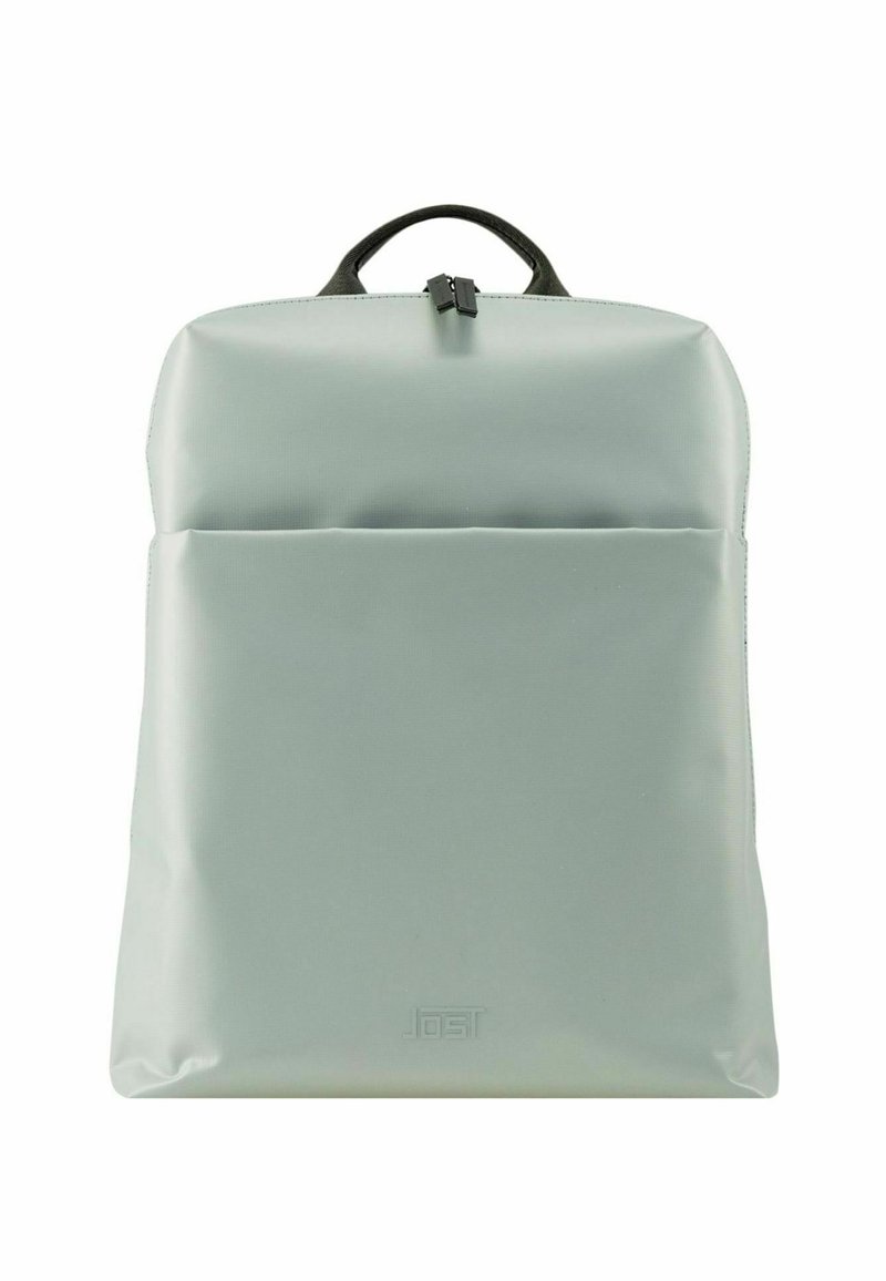 Sac à dos en nylon vert avec une texture lisse, de forme rectangulaire, une poignée supérieure et une poche zippée à l'avant. Présente un marquage subtil en bas.
