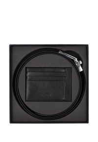 Schwarzer Ledergürtel mit einer glänzenden silbernen Schnalle, verpackt mit einem schwarzen Kartenetui mit mehreren Fächern, in einer schwarzen Box.