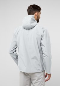 Lichtgrijze waterdichte jas met een capuchon, voorzien van een gladde textuur, ergonomisch ontwerp en minimalistische details op de schouders en mouwen.