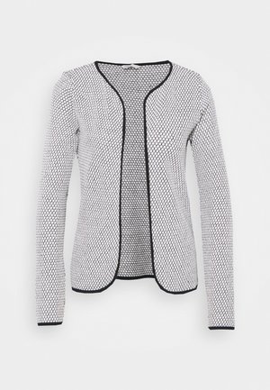 Cárdigan de mujer blanca de frente abierto con patrón hexagonal negro y ribete negro en los bordes y puños, mangas largas y escote redondo.