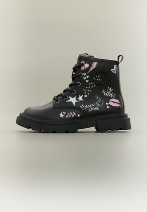 Black lace-up combat boot with thick sole, decorated with pink and white stars, hearts, lips, lightning, and the phrases "LOVE" and "Born to shine."