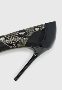 Must musta nahk kingad, millel on ülemises osas madusid meenutav võrkpind, terav nina ja stiletto konts.