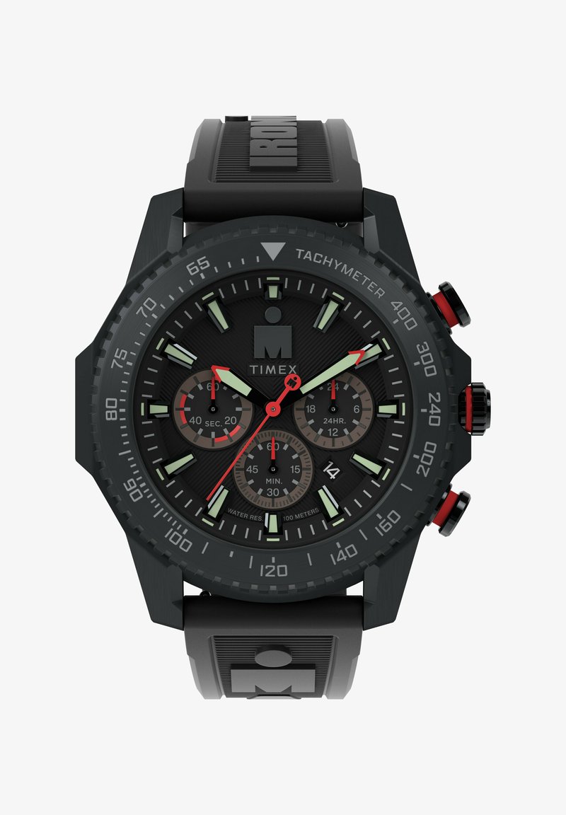 Black Timex watch with a textured rubber strap, round case, green luminescent hour markers, red accents, and multiple sub-dials.