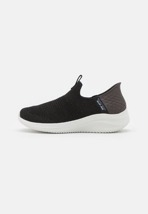 Schwarzer Slip-On-Sneaker mit einem strukturierten Strickobermaterial und einem grauen Akzent an der Rückseite. Verfügt über eine weiße, leichte Sohle mit einem gerippten Muster.