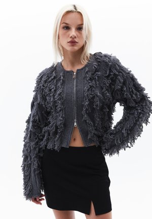 Grauer Fransen-Cardigan mit gerippter Textur, Reißverschluss und lockerer Passform. Das Design verfügt über lange, zottelige Ärmel und eine cropped Länge.