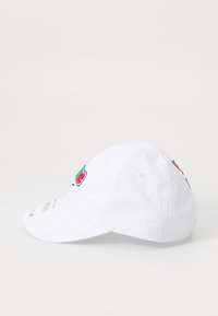 Balta beisbolo kepurė, pagaminta iš medvilnės, su raudonais, žaliais ir mėlynais siuviniais vaisių motyvais, ant viršaus yra ventiliacijos angos.