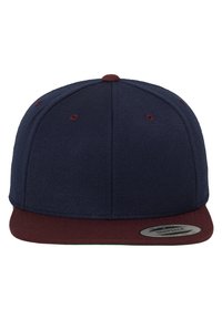 Marineblaues Basecap mit einem kastanienbraunen Schirm, strukturierte Gestaltung, Textur des Stoffes und einem verstellbaren Snapback-Verschluss. Enthält ein rundes Logodetail.