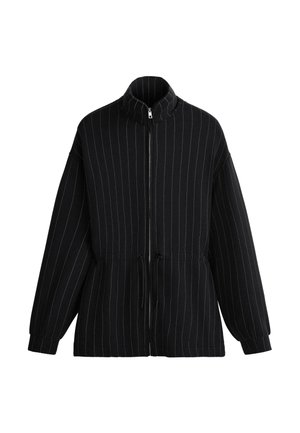 Giacca nera con zip, sottili righe verticali bianche, colletto alto, coulisse in vita e maniche lunghe con estremità risvoltate.