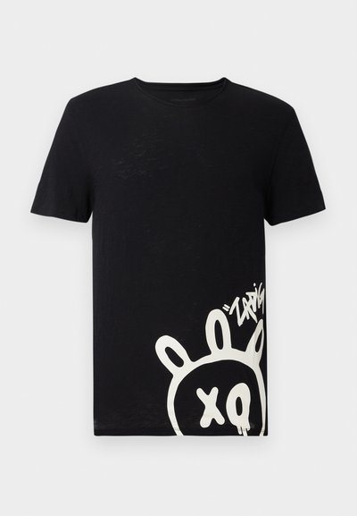 T-shirt de algodão preta com uma grande ilustração branca de um coelho em estilo cartoon com orelhas e o texto "xq", localizado no lado esquerdo.