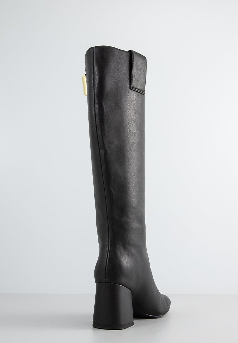 Schwarzer Lederstiefel bis zum Knie mit einem klobigen Absatz, glatter Textur und seitlichem Klappen-Detail. Minimalistisches Design und schlanke Silhouette.