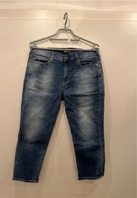 Blue denim jeans with a straight-leg fit, featuring a front button closure, five pockets, and subtle fading details.