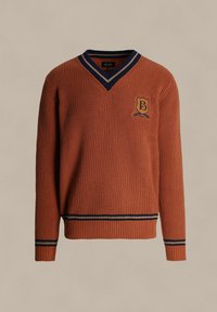Pomarańczowy sweter dzianinowy z dekoltem w kształcie litery V, granatowym kołnierzem w paski oraz niebieskim emblematem z literą "B" na piersi. Ściągacze na mankietach i u dołu.