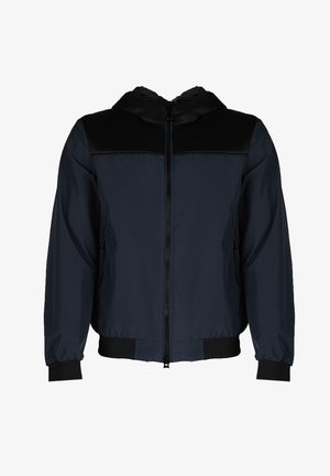 Giacca bomber blu navy con cappuccio in rete, zip frontale, polsini elasticizzati e due tasche laterali. Realizzata in tessuto liscio con una leggera lucentezza.