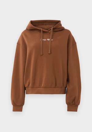 Ruskea lyhyt huppari pehmeästä kankaasta, jossa on huppu, nyörit ja ribbikuvioidut hihansuut. Edessä on valkoinen logo.