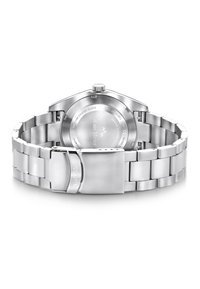 Montre en acier inoxydable avec un bracelet en métal et une finition polie. Présente un boîtier rond simple et un fermoir sécurisé. Le dos affiche les détails de la marque.