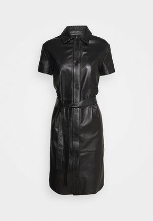 Robe chemise en cuir noir à manches courtes avec fermeture à boutons et ceinture assortie, présentée sur un fond blanc uni.