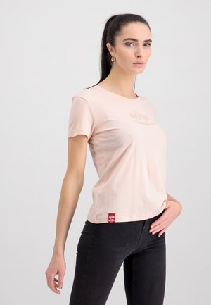 Short-sleeve, pale pink t-shirt made of soft fabric featuring a small, embossed logo on the front and a red tag on the left side.