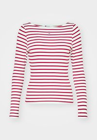 Valkoinen pitkähihaiselta paita, jossa on vaakasuoria punaisia pintoja ja pieni Tommy Jeans -logo keski-etupuolella lähellä kaula-aukkoa.