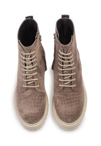 Bottines en suède marron avec un motif crocodile, lacets beiges et semelle épaisse de couleur crème. Présentent une fermeture éclair sur le côté.