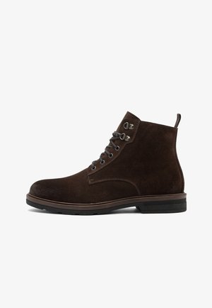 Botine din suede maro închis, cu șireturi, ochiuri metalice, tab pentru apucare la călcâi și talpă low din cauciuc negru.