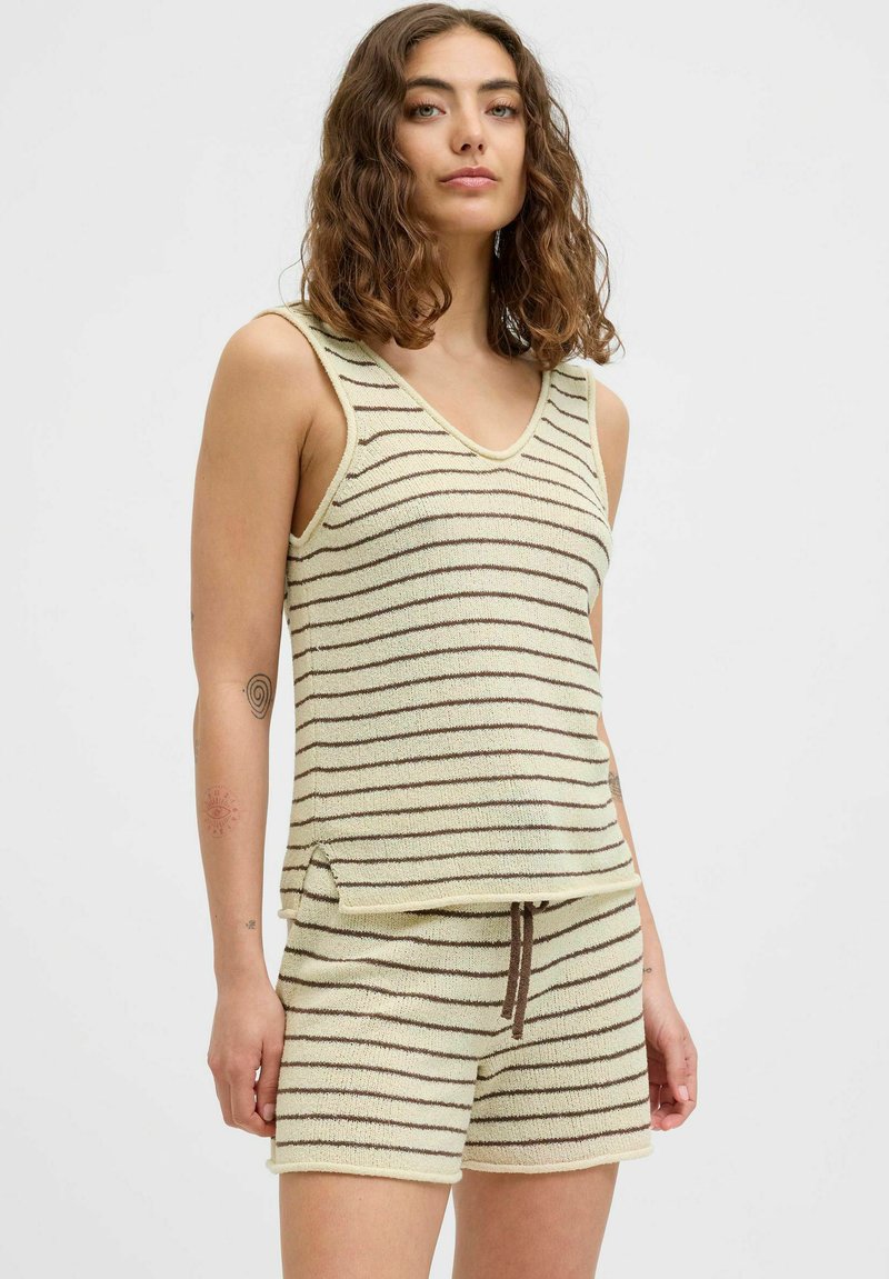 Ensemble débardeur rayé et shorts en tissu doux crème avec des rayures brunes, comportant un col en V, des fentes latérales et un cordon de serrage sur les shorts.