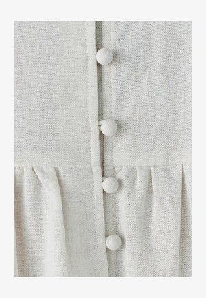 Lys beige linned kjole med knapåpning foran, runde stofbetrukne knapper og en samlet skørtsektion med subtil tekstur.