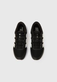 Mustad spordijalatsid võrgukattega ülaservas ja polsterdatud kraega. Omavad valgeid triibu ja paelu. Põhjaks kumm, millel on tekstuuriga haardepind.