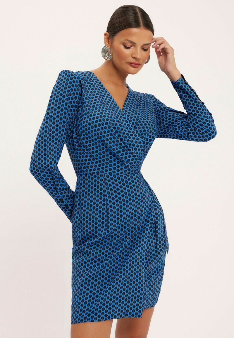 Niebieska sukienka w stylu wrap z czarnym diamentowym wzorem, długimi rękawami i dopasowaną talią. Gładki materiał o delikatnym połysku i długości do kolan.