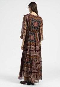 Abito maxi con maniche a campana in tessuto trasparente, caratterizzato da un motivo paisley multicolore in tonalità bordeaux, marrone e oro; vita elastica.