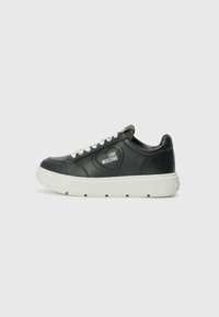 Zwarte leren sneakers met witte zolen, voorzien van een hartvormig logo en witte veters. Gladde textuur en afgerond ontwerp.