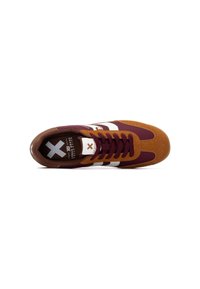 Zapatilla marrón y burdeos con rayas blancas, que cuenta con parte superior de ante, forro de tela y suela de goma marrón. Diseño con cordones.